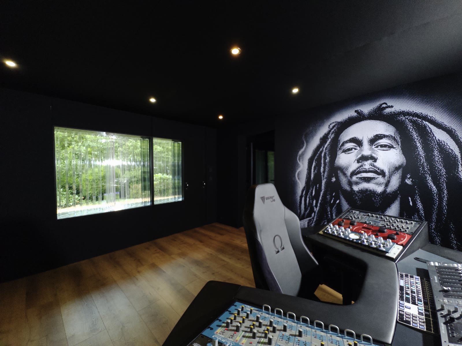 Mix position with analog gear, producer chair and the daylight rear wall in the background.